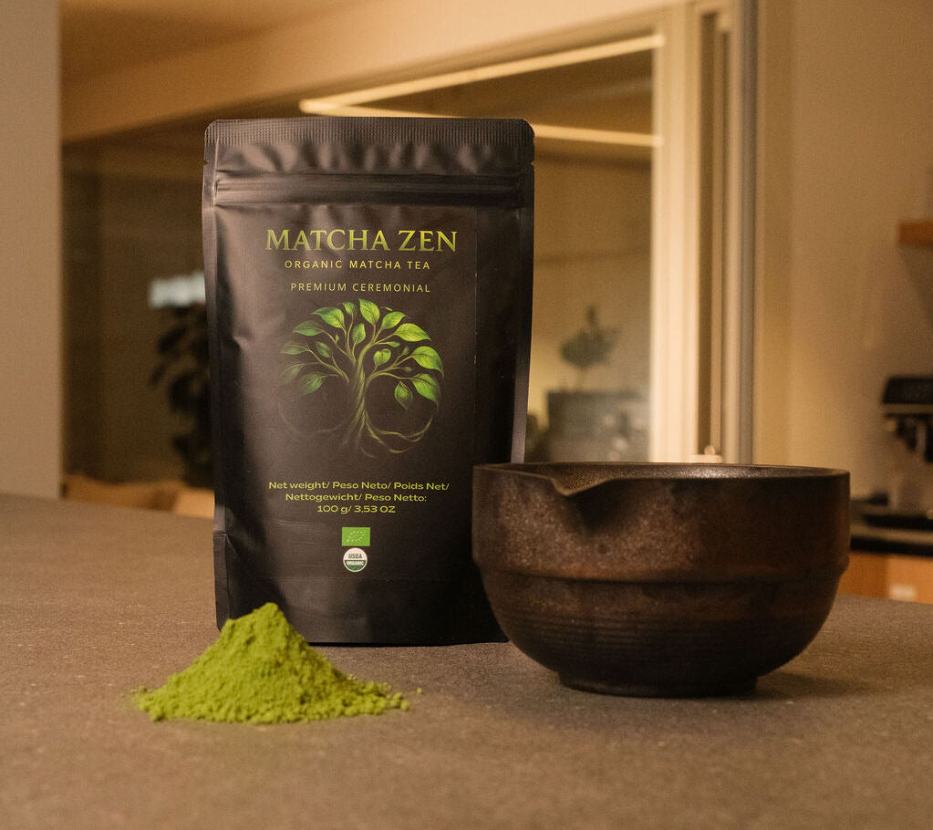 Bolsa de Matcha Zen con un montón de polvo verde delante y un cuenco vacío, con una cocina al fondo