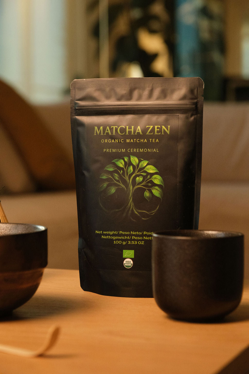 Bolsa de Matcha Zen con un cuenco, una taza y un chasen sobre una mesa de madera con luz cálida