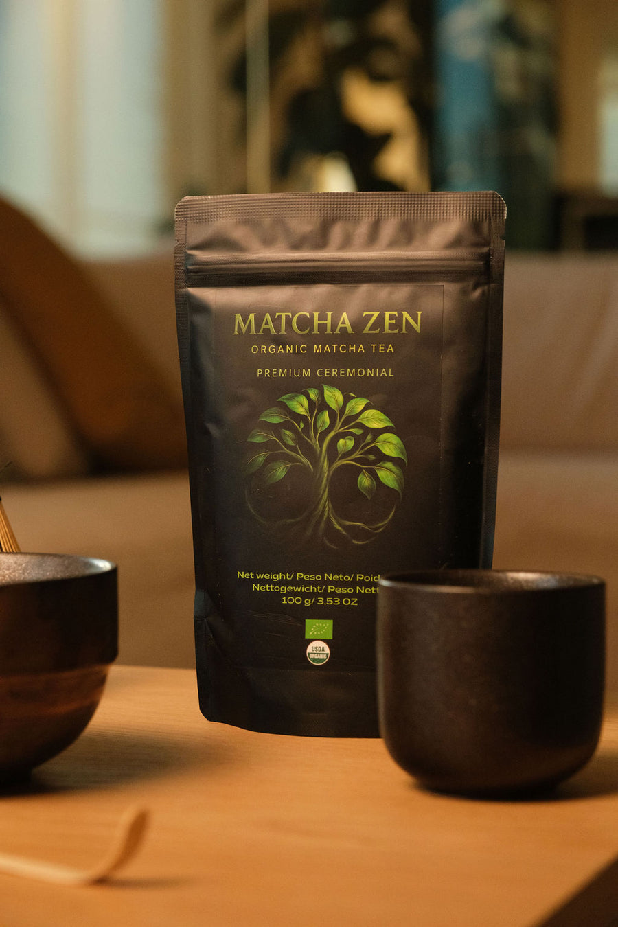Bolsa de Matcha Zen con un cuenco, una taza y un chasen sobre una mesa de madera con luz cálida