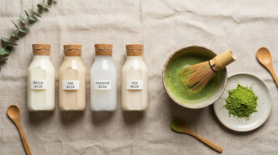 Cuatro tipos de leche junto a un bol de matcha con batidor de bambu chasen